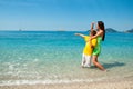 Happy mom and son on sea beach looking