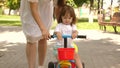 Happy mom teaches little daughter to ride a bike. mother is playing with child outdoors. child learns to ride bicycle Royalty Free Stock Photo