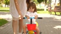 Happy mom teaches little daughter to ride a bike. mother is playing with child outdoors. child learns to ride bicycle Royalty Free Stock Photo