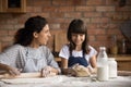 Happy mom teaching cute daughter girl to bake, rolling Royalty Free Stock Photo