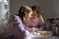 Happy mom and teenage daughter laughing studying together at home Royalty Free Stock Photo