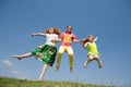 Happy Mom and two daughter jumping on meadow Royalty Free Stock Photo
