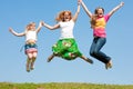 Happy Mom and two daughter jumping on meadow Royalty Free Stock Photo