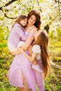 Happy mom and two daughters in a blossoming spring garden. parental love. Royalty Free Stock Photo