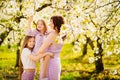 Happy mom and two daughters in a blossoming spring garden. parental love. Royalty Free Stock Photo