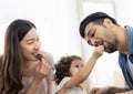 Happy moment family eating chocolate cookie in living room at home. Father Mother and daughter laughing having a good meal in the Royalty Free Stock Photo