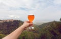 Happy moment with glass of wine in hand of tourist, in natural landscape of green valley. Homemade beverage Royalty Free Stock Photo