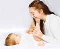 Happy moment mother playing with baby in bed