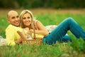 Happy moments of new family concept. Portrait of beautiful young couple having picnic in countryside. Smiling man and woman in tre Royalty Free Stock Photo