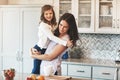 Happy in moms arms. a happy mother hugging her cute little girl in the kitchen at home. Royalty Free Stock Photo