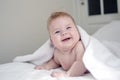 Happy 4 month baby boy or girl lying on a white towel after the morning bath Royalty Free Stock Photo