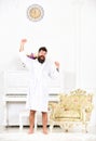 Happy morning concept. Hipster enjoy morning while stretching arms near piano and old fashioned armchair. Man cheerful Royalty Free Stock Photo