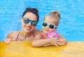 Happy mother and adorable little daughter having fun in a swimming pool Royalty Free Stock Photo