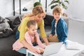 happy mother with adorable smiling children using laptop together Royalty Free Stock Photo