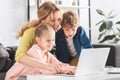 happy mother with adorable smiling kids using laptop together Royalty Free Stock Photo