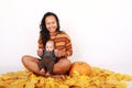 Happy mother and baby boy sitting on maple leaves by pumpkin Royalty Free Stock Photo