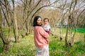 happy mother and baby daughter standing together under a tree in the countryside, smiling with love and affection. A perfect Royalty Free Stock Photo