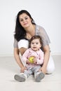 Happy mother with baby girl holding an apple Royalty Free Stock Photo