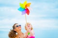 Happy mother and baby girl holding windmill Royalty Free Stock Photo