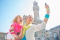 Happy mother and baby girl making selfie in florence, italy