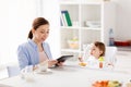 Happy mother and baby having breakfast at home Royalty Free Stock Photo