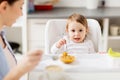Happy mother and baby having breakfast at home Royalty Free Stock Photo