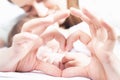 Happy mother and baby. Heart symbol by hands. Family care
