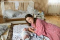 Happy mother with baby at home. Young mother holding her newborn baby. A woman and a newborn boy are resting in the bedroom with a Royalty Free Stock Photo