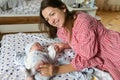 Happy mother with baby at home. Young mother holding her newborn baby. A woman and a newborn boy are resting in the bedroom with a Royalty Free Stock Photo