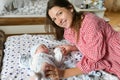 Happy mother with baby at home. Young mother holding her newborn baby. A woman and a newborn boy are resting in the bedroom with a Royalty Free Stock Photo