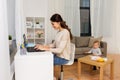 Happy mother with baby and laptop working at home