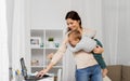 Happy mother with baby and laptop working at home Royalty Free Stock Photo