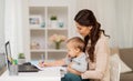 Happy mother with baby and papers working at home Royalty Free Stock Photo