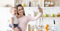 Happy mother with baby photographing themselves on cellphone Royalty Free Stock Photo