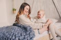 Happy mother and baby playing at home in bedroom. Cozy family lifestyle Royalty Free Stock Photo