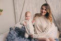 Happy mother and baby playing at home in bedroom. Cozy family lifestyle