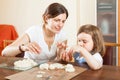 Happy mother and baby sculpting from plasticine or dough in home