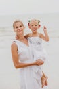 Happy mother and baby on the sunset at the beach. Royalty Free Stock Photo