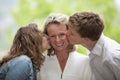 Happy mother being kissed by daughter and son