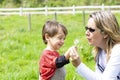 Happy mother and boy blowing dandelion Royalty Free Stock Photo