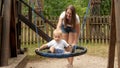 Happy mother and boy swinging in the round rope nest swing on the playground. Kids playing outdoors, children having fun, summer Royalty Free Stock Photo