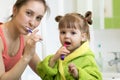 Happy mother and kid daughter brushing their teeth at home in the bathroom Royalty Free Stock Photo