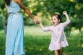 Happy mother and child daughter holding hands together in day Royalty Free Stock Photo