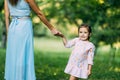 Happy mother and child daughter holding hands together in day Royalty Free Stock Photo