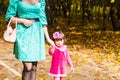 Happy mother and child daughter holding hands together in summer or autumn day. Royalty Free Stock Photo