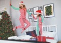 happy mother and child daughter in pajamas jumping in bed on christmas morning . Royalty Free Stock Photo