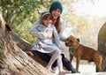 Happy mother, child and dog with hug for bonding and quality time outside in nature on winter break. Family, woman and Royalty Free Stock Photo