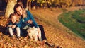 Happy mother with a child and a dog walking outdoors in autumn. Young mother having fun with child and pet in sunny day. Family, Royalty Free Stock Photo