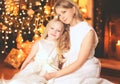 Happy mother and child near christmas tree with fireplace