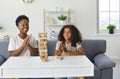 Happy mother and child sitting on couch at home, playing board game and having fun Royalty Free Stock Photo